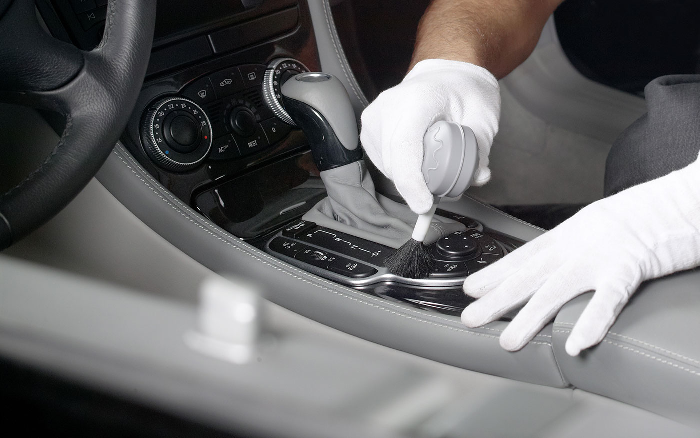 Detailer cleaning car cupholder.